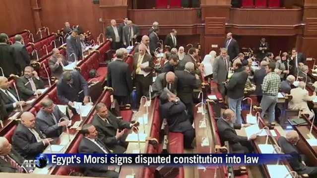 Egyptians react as Morsi signs disputed constitution into law