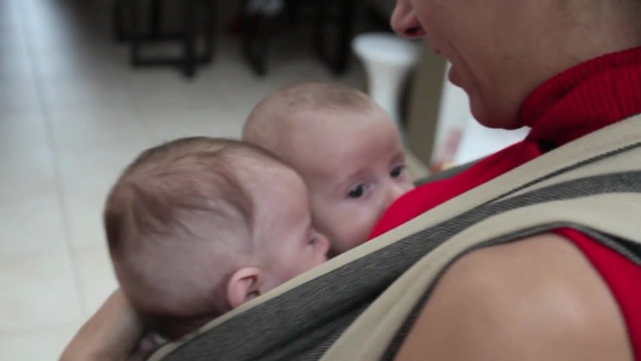 Jumeaux de 4 mois en écharpe de portage.
