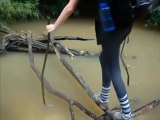 Jolie fille essaye de traverser une rivière