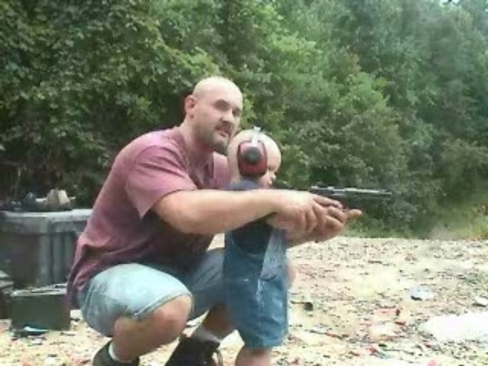 Bebe qui tire au pistolet avec papa