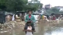 En direct des inondations, perché sur les épaules d'une victime