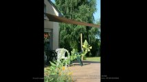 Terrasse bois composite havane chamarré et voile d'ombrage triangulaire couleur taupe
