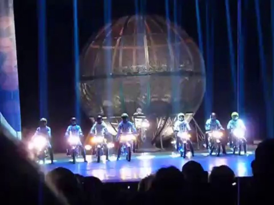 Acrobats ride eight motorbikes inside a sphere