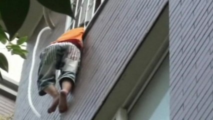 Boy hanging from 4th floor window is rescued