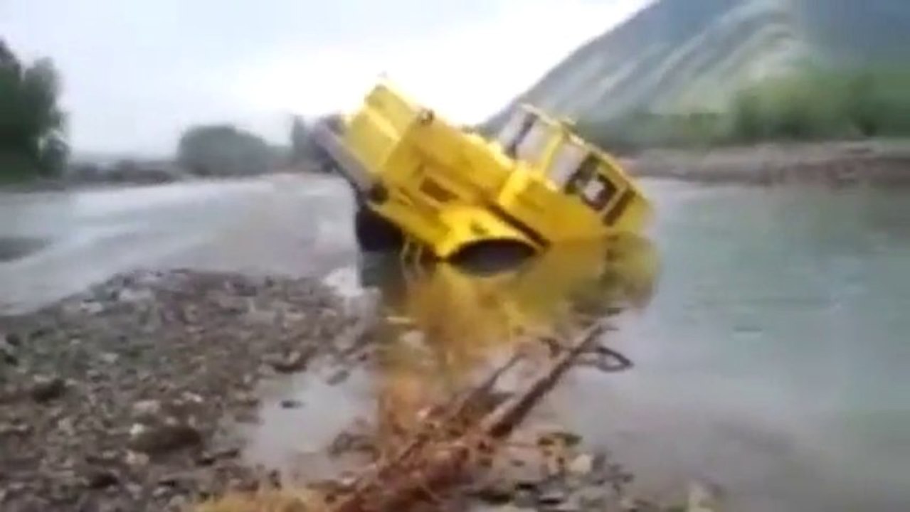 Russian tractor driver refuses to give up after his vehicle gets stuck in a river - Caterpillar Truck