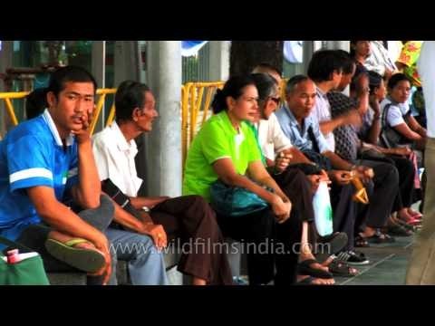 People waiting at a bus stop shelter for their buses in Thailand