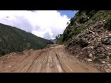 Car driving through a damaged section of road between Rudraprayag and Gauchar