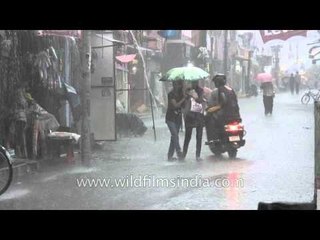 Two girls walking in the rain with umbrella