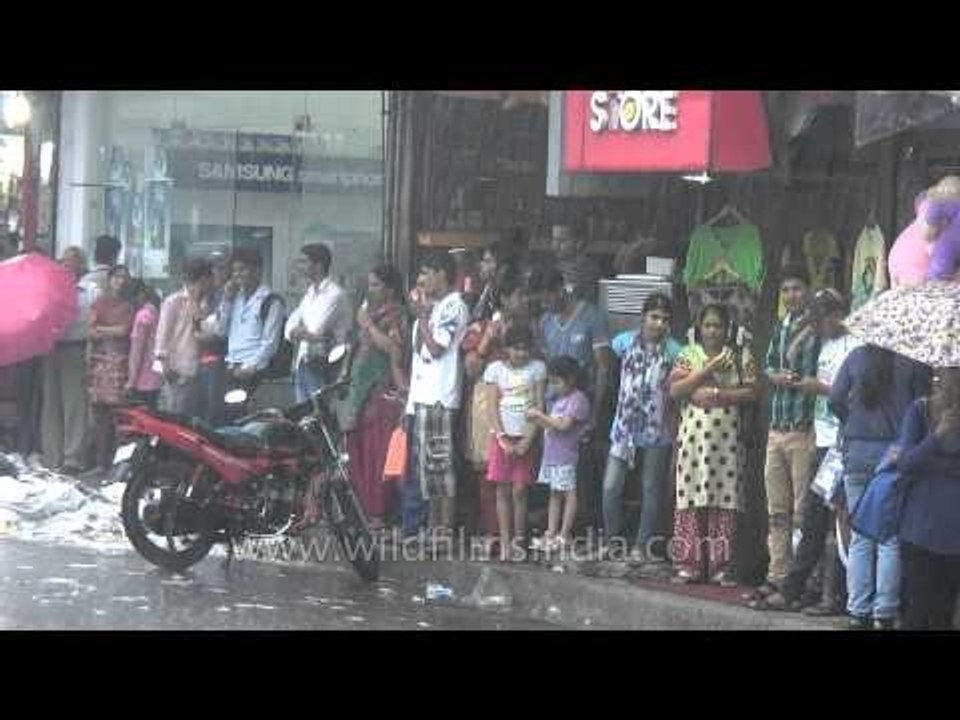 People patiently waiting under the shed to avoid getting wet