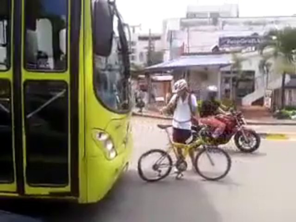 Un cycliste freine devant un bus