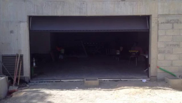 Porte de garage sectionnelle plafond Sécura motorisée et posée par APG Accès Portes de Garage