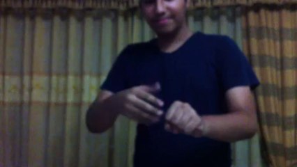 A boy showing how to make a coin disappear and reappear in thin air