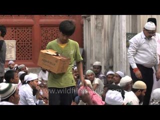 Boy distributing water to the fasting people for Iftar
