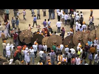 People carrying large wooden shields for Bagwal