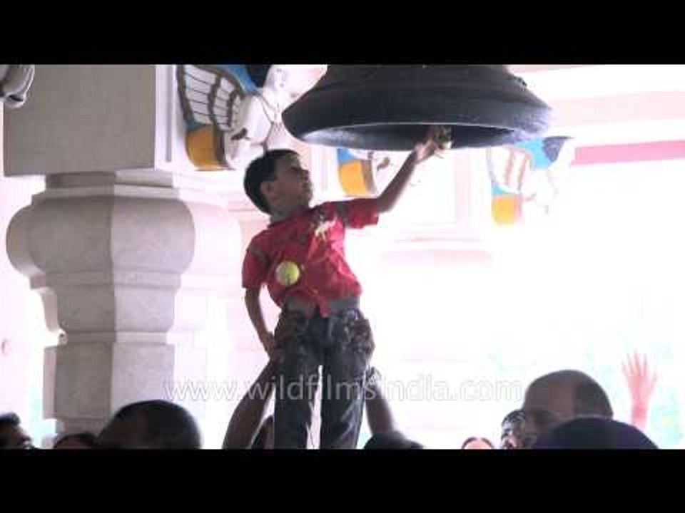 Child hoisted up to ring the temple bell at Birla Mandir