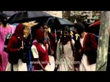 School children under umbrellas during rain showers in Munnar