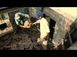 Potters picking up stoneware from furnace