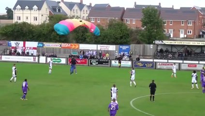 Un parachutiste se pose sur un terrain de foot en plein match !