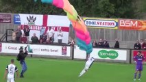 Un parachutiste atterrit au beau milieu d'un match de foot