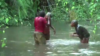 Une femme et ses enfants jouent de la musique avec l'eau d'une rivière