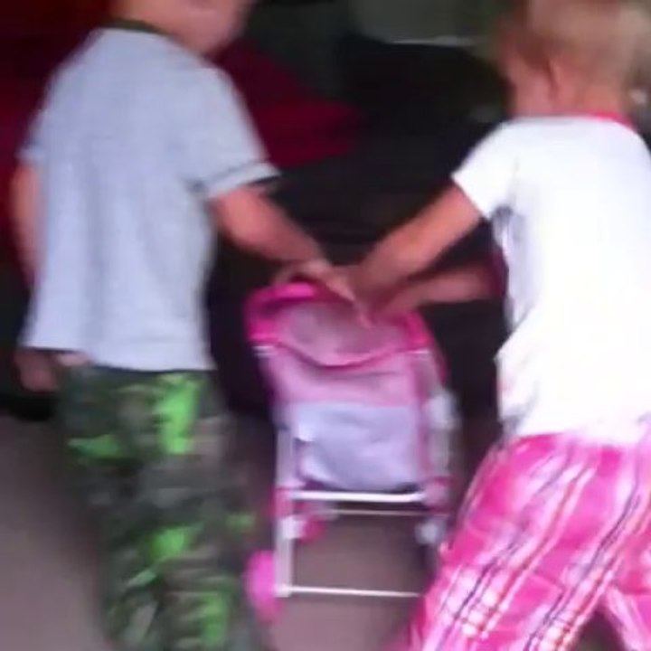 Jayce pushing Laci in a stroller around the house. Too cute