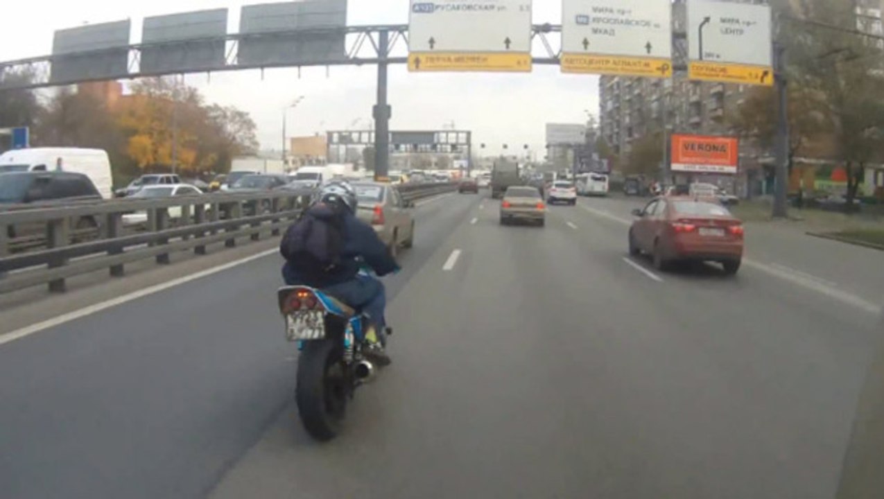 Un motard freine entre des voitures
