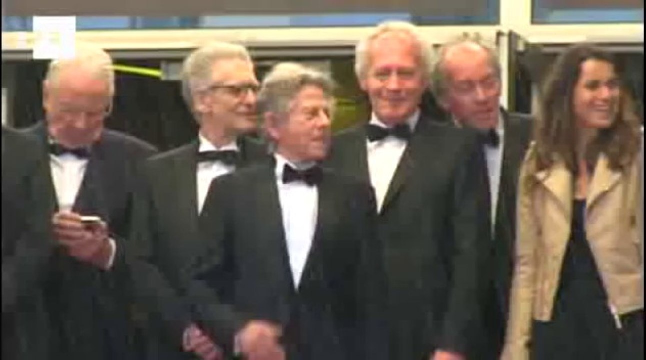 Roman Polanski reaparece no tapete vermelho de Cannes sob chuva.