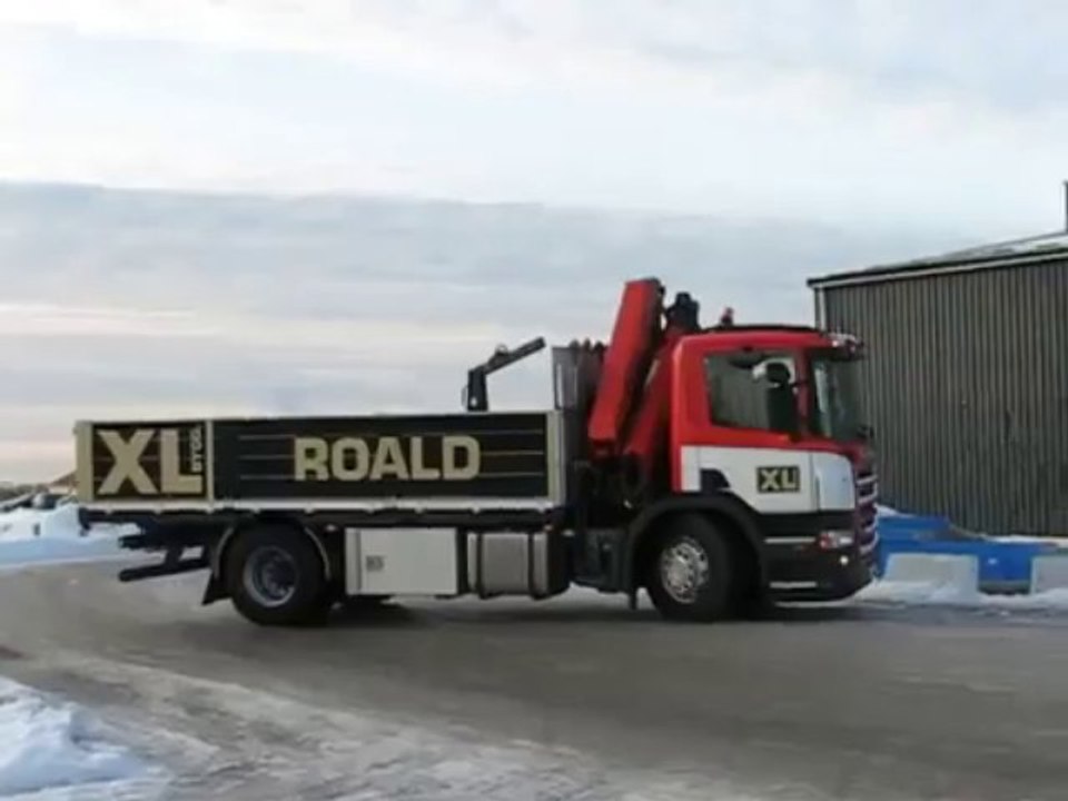 Un camion qui fait un gros drift sur de la glace avant de rentrer dans un entrepôt