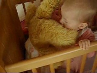 Bébé dans son lit avec son nounours