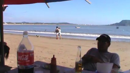 PERRITO EN LA PLAYA CON BOTELLA DE AGUA EN EL HOCICO