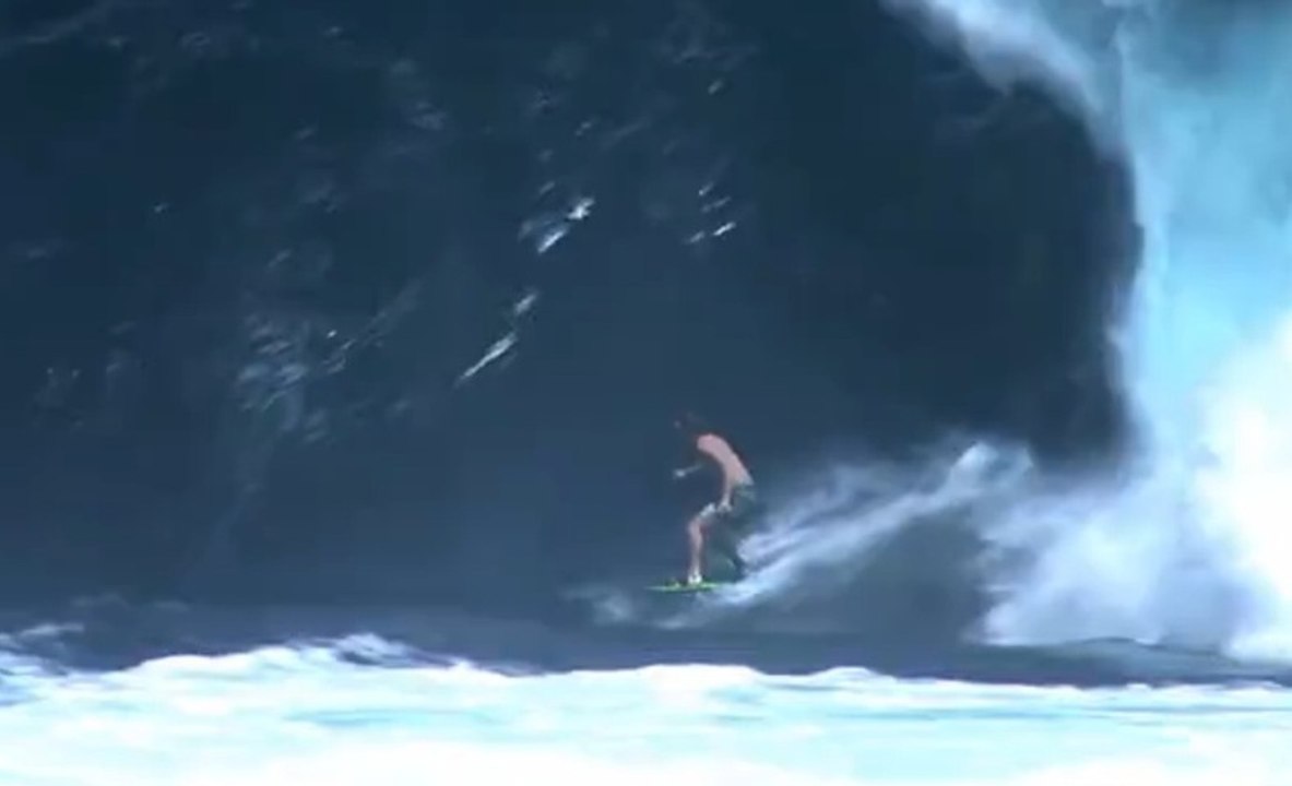 Il se fait une bière en surfant une énorme vague!!