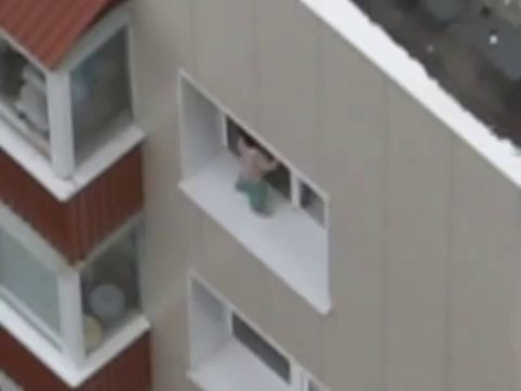 Un bébé sur le rebord d'une fenêtre au 11ème étage