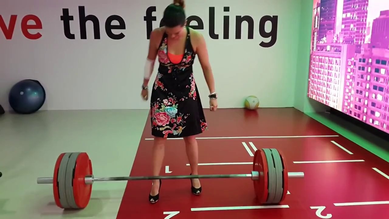 Femme fait de l'haltérophilie en talons hauts