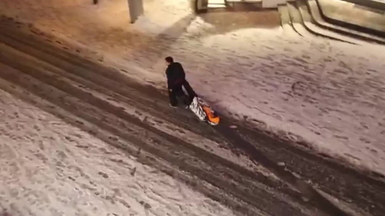 Des russes traînent leur pote ivre dans la neige