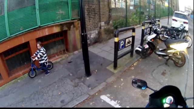 Enfant à vélo contre grosse moto. Magique!