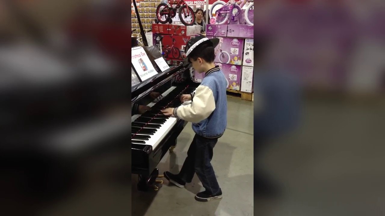 Un enfant joue du piano dans un magasin