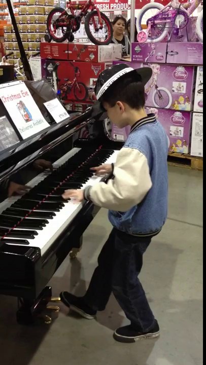 Un enfant surdoué fait une démo de piano dans un magasin.