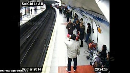Un policía auxilia a un hombre que había caído al Metro