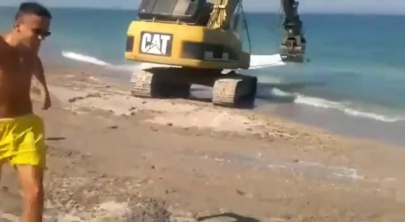 Fun at the beach with a backhoe