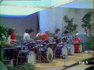 Dante Agostini et des jeunes batteurs dans un numéro musical