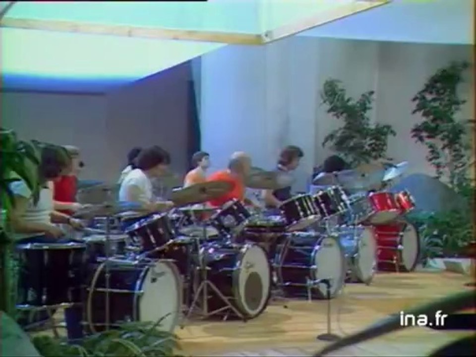 Dante Agostini et des jeunes batteurs dans un numéro musical