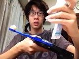 Asian brushes teeth with gun