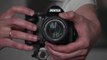 Photographer is zooming a lens and taking a picture with a DSLR photo camera. Slow motion