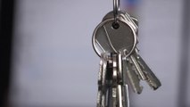 Janitor holds and wiggles key chains, rings and cases. Slow motion HD video footage