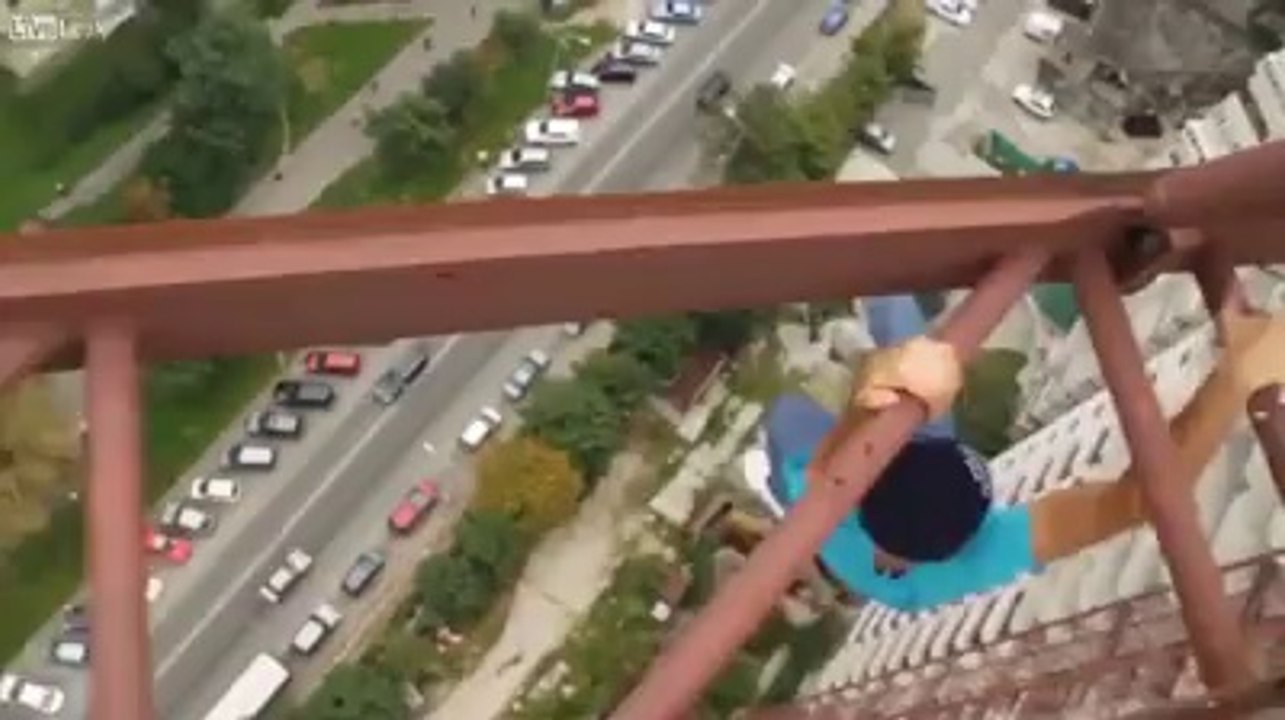 very very brave man walking on very high weight lifter.