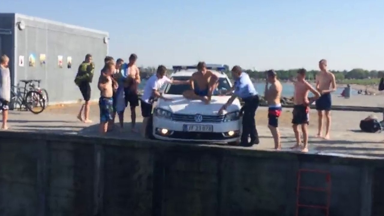 Faire du toboggan sur le capot d'une voiture de police