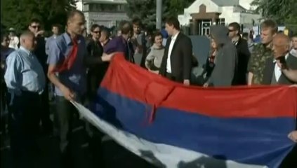 Des Ukrainiens décrochent le drapeau de l'ambassade de Russie à Kiev