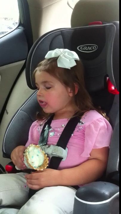 Une petite fille dort et mange sa glace