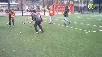 Crianças de Haia correm atrás da bola, mas com taco na mão