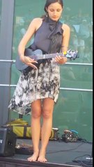 a beautiful girl is playing guitar without shoes
